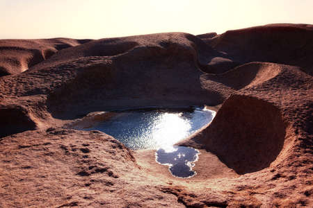 Water in the desert mountains and sun glareの写真素材