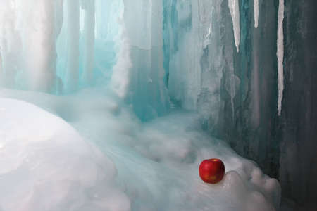Red apple inside a frozen waterfallの写真素材