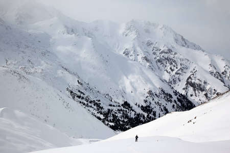 Backpacker man in winter mountainsの写真素材