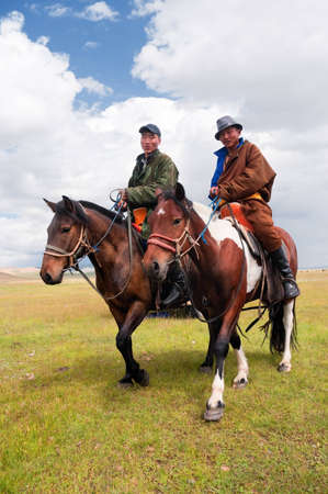 MONGOLIA - AUGUST 06: Mongolians in national clothes herding horses in a mountain valley on August 06, 2011 in Mongoliaのeditorial素材