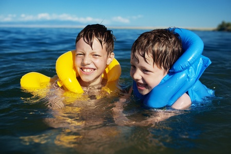Smiling brothers swimming in the life jacket