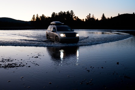 Car moves to fording the river Uur, Mongolia