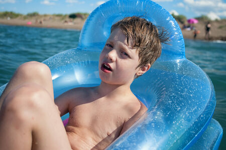 Boy swimming in inflatable boatの写真素材
