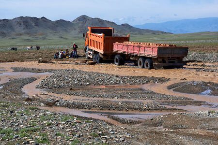 WESTERN MONGOLIA, MONGOLIA - AUG 14, 2012: Cargo transportation in the steppes of Mongolia - truck...