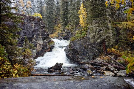 Autumn snowfall and Yazevoy Waterfall in East Kazakhstan, Altai mountainsの写真素材