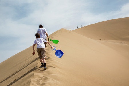 Two teenagers rise to the Singing Dunes in desert national park Altyn-Emel, Kazakhstan, Central Asiaの写真素材