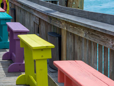 Colorful wooden benches on a wooden pier by the ocean. Bar by the sea.の写真素材