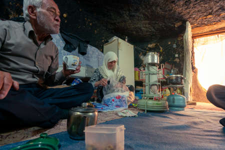 Old Iranian couple in their modest cave home, preparing for dinner. Mahan, Iran, Persia.のeditorial素材