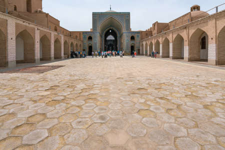 Yazd, Iran - 13.04.2019: Courtyard of historical Jameh Mosque of Yazd with its hexagonal and turquoise tiles. People walking in the yard of Shia mosque. Persia.のeditorial素材