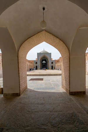 Yazd, Iran - 13.04.2019: Courtyard of historical Jameh Mosque of Yazd with its hexagonal and turquoise tiles. People walking in the yard of Shia mosque. Persia.のeditorial素材