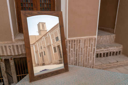 Wind tower, medieval cooling device, reflects in a mirror standing on a table in the streets of Yazd, Iran.の写真素材