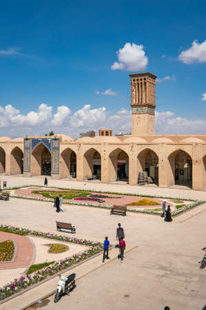Kerman, Iran - 19.04.2019: People walking around and sitting in the square and bazaar crossroads in the city of Kerman. Oriental urban architecture. Fountain in the middle.のeditorial素材