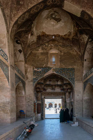 Kerman, Iran - 19.04.2019: People walking around and sitting in the square and bazaar crossroads in the city of Kerman. Oriental urban architecture. Fountain in the middle.のeditorial素材