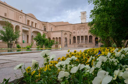 Kashan, Iran - 04.19.2019: Courtyard of richly decorated Borujerdi House, famous historical home from Qajar era. Pool, wind towers, small persian garden.のeditorial素材