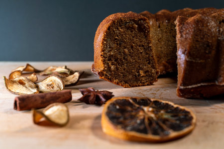 Still life with homemade cake, jar with honey and dipper, cinnamon, dried fruits, star anise on a wooden board. Small healthy snacks to enjoy during coffee break.の写真素材