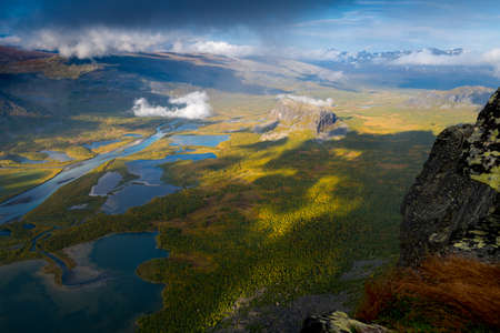 Beautiful, wild arctic valley viewed from mountain top in epic early morning light. Remote Rapa river valley from the top of Skierfe in Sarek national park in Swedish Lapland. Autumn colors.の写真素材