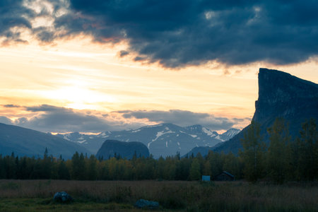 Epic sunset in wild, beautiful arctic landscape of northern Sweden. Skierfe mountain and Rapa river valley in early autumn evening. Sarek National Park. Sun sets on the horizon.の写真素材