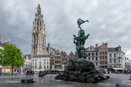 Antwerp, Belgium - 04.29.2018: Old houses in Grote Markt with Brabo Fountain in the front and tower of Cathedral of Our Lady in the back on a cloudy day. Old town of Antwerp.のeditorial素材