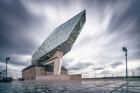 Antwerp, Belgium - 04.29.2018: Low angle, long exposure shot of modern building of Port Authority Building on a cloudy, rainy day. Famous architecture of Belgium.のeditorial素材