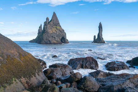 Waves hit the coast of the black beach in Vik i Myrdal, Iceland. Spray of water on the rock.