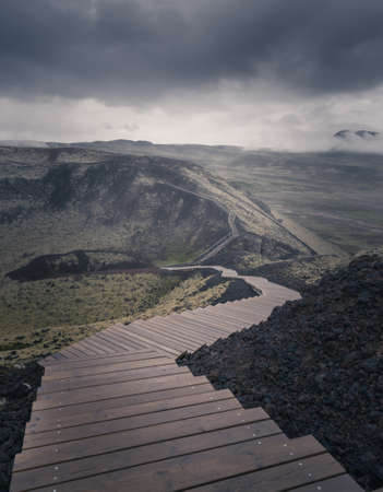 Stairs on a hill leading to the mist. Moody view in dramatic Icelandic landscape. Vanishing pathway.の写真素材