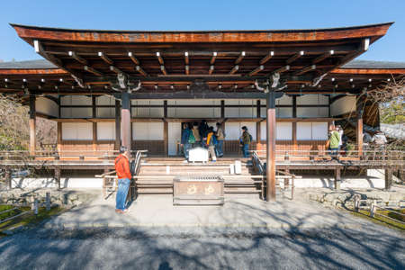 Kyoto, Japan - 2017.12.01: People entering small ancient Buddhist temple in Arashiyama district