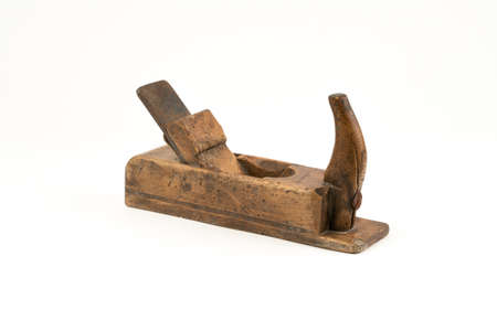 Horizontal high angle angle studio shot of small vintage wood planer isolated on white background. Old carpenter tool with wood worm holes in it. Carpentry concept.の写真素材