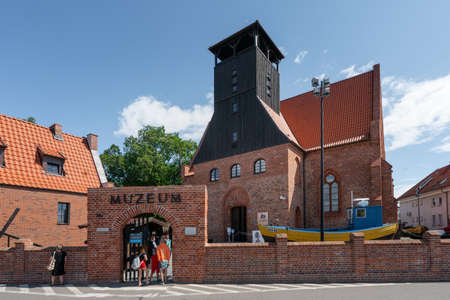 Hel, Poland - 08.01.2021: People entering red brick building of The Museum of Fishing in Hel, a department of the National Museum of the Sea. Beautiful sunny summer day.のeditorial素材