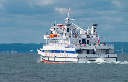 Hel, Poland - 08.01.2021: A passenger boat with people onboard on its way across Baltic sea from Hel to Gdansk on a hazy warm summer day. Summer holiday at the Baltic coast. Cruising ferry.のeditorial素材
