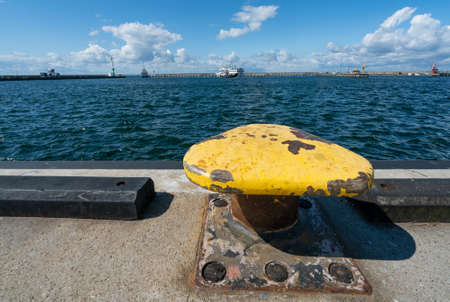 Yellow steel knob on a concrete ocean pier in the port of Hel, Poland. Beautiful sunny summer day on a Baltic coast.の写真素材