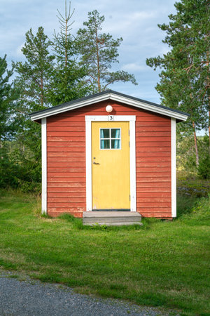 Anaset, Sweden - 08.22.2021: Exterior of typical red wooden Swedish cabin with white window and door frames. Camping in Sweden. Summer holiday and travel in Scandinavia.のeditorial素材