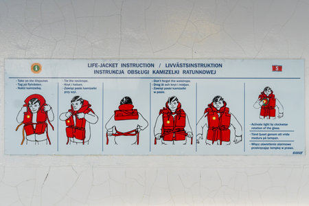 Karlskrona, Sweden - 08.14.2021: Life vest instructions in English, Swedish and Polish attached to wall onboard Stena Line Spirit ferry.のeditorial素材