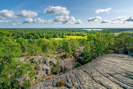 Beautiful summer day in Swedish landscape of Segersgarde nature reservation. Green forests, meadows view from the top of the rock. Summer holiday in Sweden.の写真素材