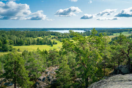 Beautiful summer day in Swedish landscape of Segersgarde nature reservation. Green forests, meadows view from the top of the rock. Summer holiday in Sweden.の写真素材
