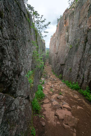 Slattdalsskrevan Canyon in Skuleskogen National Park, Sweden. Narrow crevasse in solid rock on a cloudy summer day. Hiking along the High Coast Trail in Sweden. Hohe Kustenleden trail.の写真素材