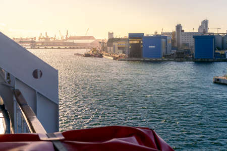 Gdynia, Poland - 09.23.2021: Sunrise in the port viewed from the deck of cruising ship. Blue Damen building.のeditorial素材