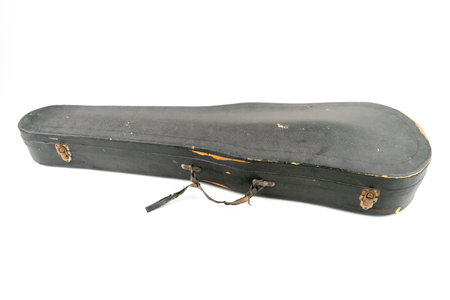 Detail studio shot of old, black, scratched violin case, isolated on white background. Concept for arts, restoration, repair. Vintage damaged case of classical musical instrument.の写真素材