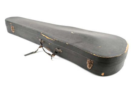 Detail studio shot of old, black, scratched violin case, isolated on white background. Concept for arts, restoration, repair. Vintage damaged case of classical musical instrument.の写真素材