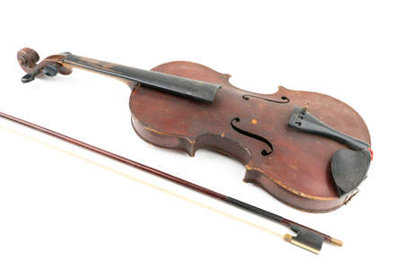 Wide closeup studio shot of old, broken, dust covered violin isolated on white background. Vintage damaged musical instrument. Concept for restoration.の写真素材