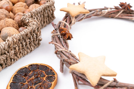 High angle studio shot of handmade, dry Christmas wreath with gingerbread stars and star anises isolated on white background. Christmas concept. Traditional hand work. Mixed nuts and dried fruits.の写真素材
