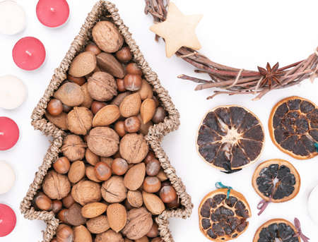 Detail top studio shot of handmade, dry Christmas wreath with gingerbread stars and star anises isolated on white background. Christmas concept. Traditional hand work. Candles, nuts and dried fruits.の写真素材
