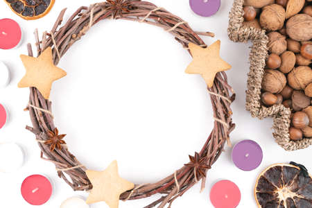 Detail top studio shot of handmade, dry Christmas wreath with gingerbread stars and star anises isolated on white background. Christmas concept. Traditional hand work. Candles, nuts and dried fruits.の写真素材