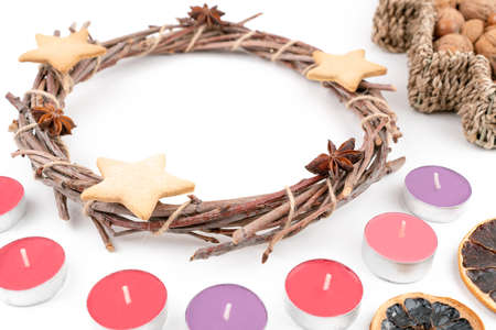 High angle studio shot of handmade, dry Christmas wreath with gingerbread stars and star anises isolated on white background. Christmas concept. Traditional hand work. Candles, nuts and dried fruits.の写真素材
