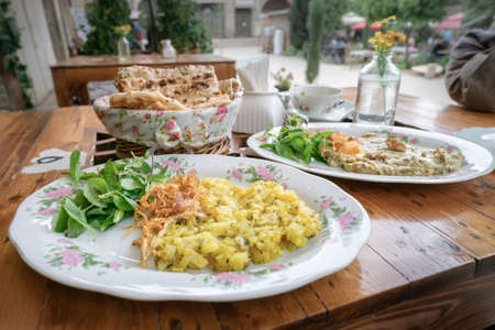 Two plates of traditional Iranian food on the wooden table of restaurant in Kerman, Iran,の写真素材