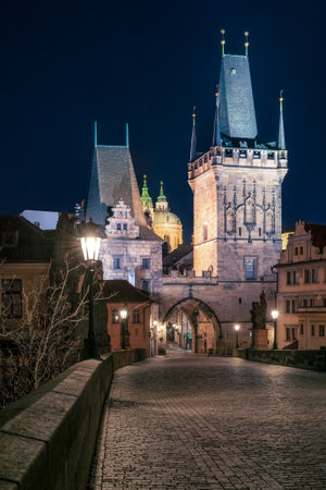 Prague, Czechia - 02.17.2022: View of Mala Strana Bridge Towers from Charles Bridge in the dark night. Prague center without people. Beautiful historical buildings in central european capital.のeditorial素材