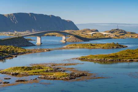 Fredvang bridges across fjord of Lofoten Islands in Norway on a beautiful day of arctic summer with dramatic steep rock cliffs and mountains on the horizon. Hiking in remote northern wilderness.の写真素材