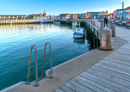 Helgoland, Germany - 02.27.2022: Wooden walk by the bay in the port of Helgoland. Sunny winter day...
