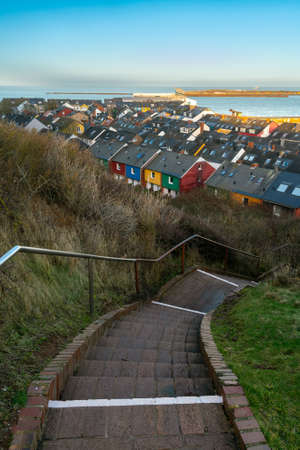 Vertical cityscape of Helgoland, Germany, taken from the cliff above the city. Staircase going down in the front, on a sunny day of winter.のeditorial素材