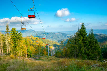 Old cableway with red seats abandoned on a beautiful day of summer. Beskid mountains, Caprathian range, Czech Republic.の写真素材