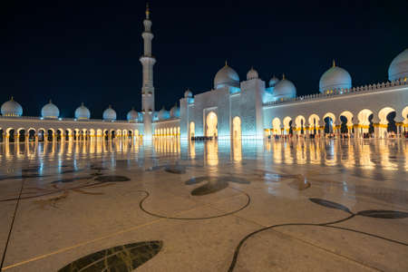 Abu Dhabi, UAE - 11.03.2017: Night at the courtyard of Grand Mosque of Abu Dhabi. Sheikh Zayed Grand Mosque.Marble floor and richly decorated arches.Contemporary Islamic architecture. Minaret and domeのeditorial素材